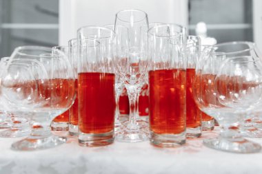 Şenlik masası için bardak servisi. İçki bardakları, şampanya ve meyve suyu. Masayı hazırla. Kompotlu bardaklar. Yakın plan.