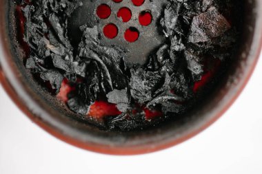 Sigara içtikten sonra kırmızı silikonlu nargile kasesi ve yanık meyve tütünü. Yakın plan. Beyaz bir arka planda. Yukarıdan görüntüle