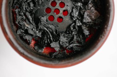 Sigara içtikten sonra kırmızı silikonlu nargile kasesi ve yanık meyve tütünü. Yakın plan. Beyaz bir arka planda. Yukarıdan görüntüle