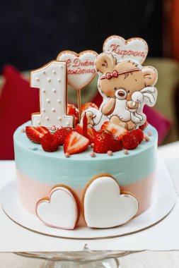 Bir çocuğun doğum günü için güzel bir doğum günü pastası. Bir kız için bir hediye. Pastanın üzerindeki süslemeler çilek, çizgi film karakterleri, kalpler. Yazı - Mutlu Yıllar Kirochka