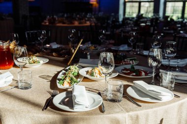 Ziyafet ya da kutlama için masa ayarlayın. İçkiler, şampanya ve meyve suyu için boş şarap kadehleri. Masayı hazırla. Tabakta kumaş peçeteler. Yakın plan..