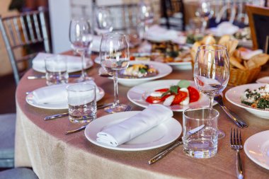 Ziyafet ya da kutlama için masa ayarlayın. İçkiler, şampanya ve meyve suyu için boş şarap kadehleri. Masayı hazırla. Tabakta kumaş peçeteler. Yakın plan..