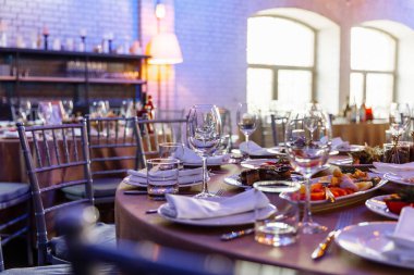 Ziyafet ya da kutlama için masa ayarlayın. İçkiler, şampanya ve meyve suyu için boş şarap kadehleri. Masayı hazırla. Tabakta kumaş peçeteler. Yakın plan..