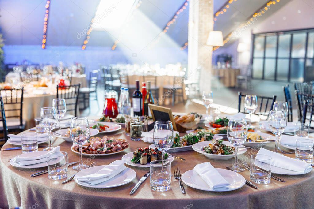 Table setting for a banquet or celebration. Empty wine glasses for spirits, champagne and juice. Set the table. Cloth napkins on a platter. Close-up.