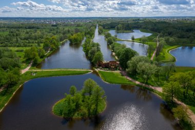 Göletlerin yüksekliğinden panoramik bir manzara Peterhof 'taki peyzaj parkı, çayır bahçesi, yürüyüş yolları, tahrip edilmiş pavyon.