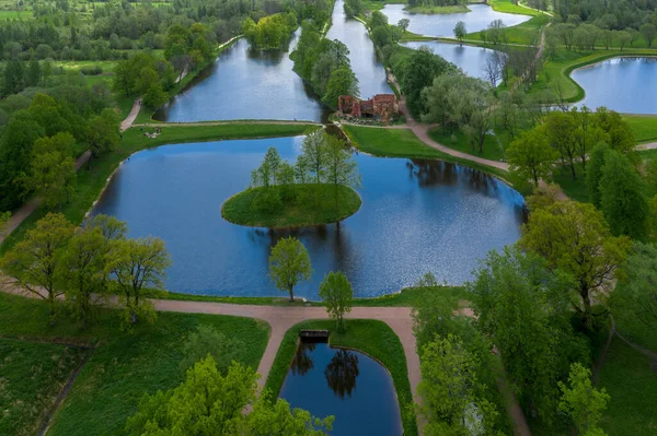 Göletlerin yüksekliğinden panoramik bir manzara Peterhof 'taki peyzaj parkı, çayır bahçesi, yürüyüş yolları, tahrip edilmiş pavyon.