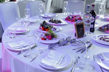 Ziyafet ya da kutlama için masa ayarlayın. İçkiler, şampanya ve meyve suyu için boş şarap kadehleri. Masayı hazırla. Tabakta kumaş peçeteler. Ziyafet salonu. Soğuk mezeler ve salatalar