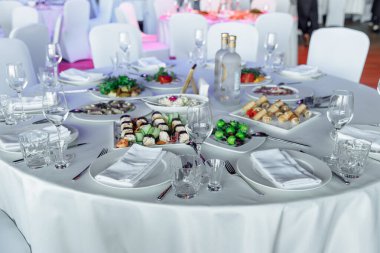 Ziyafet ya da kutlama için masa ayarlayın. İçkiler, şampanya ve meyve suyu için boş şarap kadehleri. Masayı hazırla. Tabakta kumaş peçeteler. Ziyafet salonu. Soğuk mezeler ve salatalar