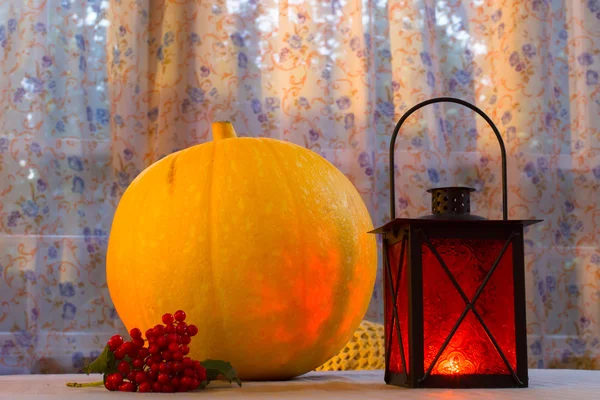 Calabaza y cesta de manzanas en Halloween en la cálida luz de las linternas, calabaza tallada . — Foto de Stock