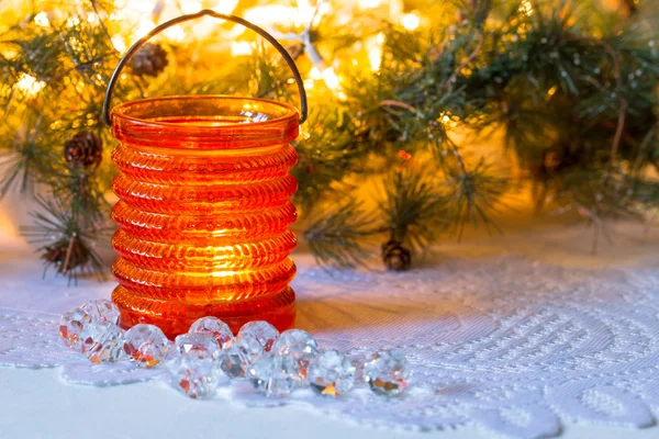 Composição de Natal com um castiçal de vidro em um fundo de luzes embaçadas — Fotografia de Stock