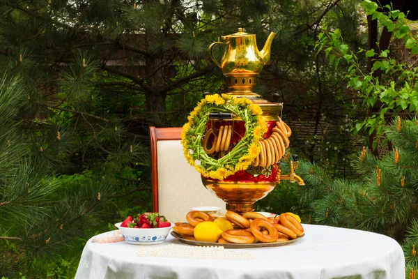 俄罗斯茶炊，茶、 Gzhel 板上的草莓、 柠檬、 鲜花、 干燥和百吉饼 — 图库照片