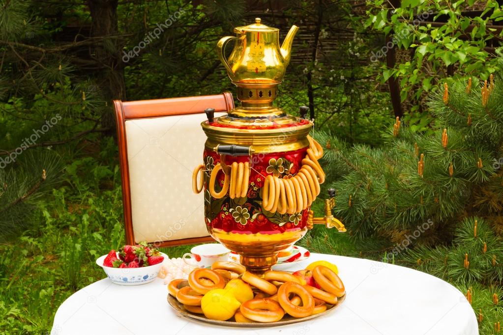 Russian samovar and tea, strawberries on the plate Gzhel, lemons, flowers, drying and bagels