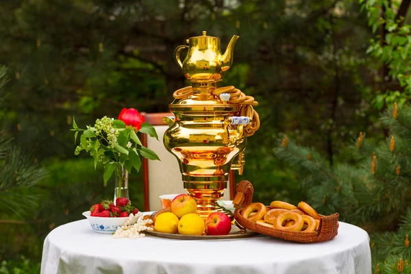 Samovar ruso y té, fresas en el plato Gzhel, limones, flores, secado y rosquillas — Foto de Stock