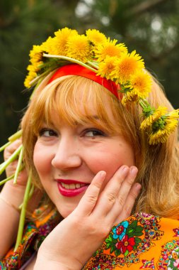 Bir çelenk taze dandel yanaklı Rus neşeli genç kadın