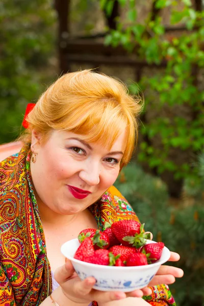 Portrait of a young woman with strawberries. She laughs, smiles, — Stock Photo, Image