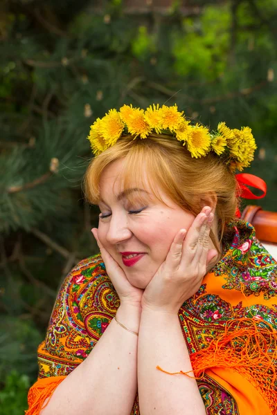 Tvářemi ruské veselá mladá žena v věnec z čerstvých dandel — Stock fotografie