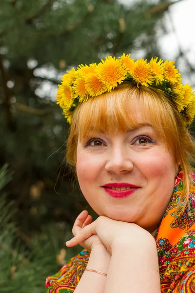 Tvářemi ruské veselá mladá žena v věnec z čerstvých dandel — Stock fotografie