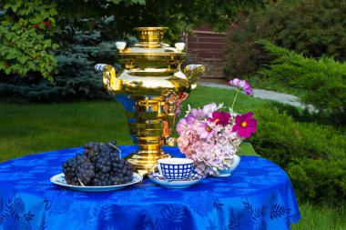 The end of the summer. Samovar, cups of tea and autumn gifts - flowers, vegetables and fruit clipart