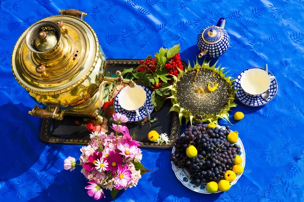 Na konci léta. Samovar, šálky čaje a podzimní dárky - květiny, zeleninu a ovoce — Stock fotografie