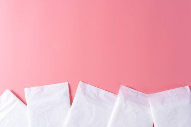 Hijyenik ped, pembe arka planda hijyenik peçete. Regl, kadın hijyeni, üst tabaka..