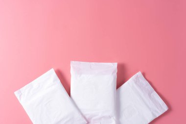 Hijyenik ped, pembe arka planda hijyenik peçete. Regl, kadın hijyeni, üst tabaka..