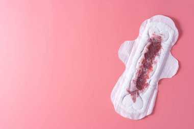 Tam kan içeren hijyenik ped, pembe arka planda hijyenik peçete. Regl, kadın hijyeni, üst tabaka..