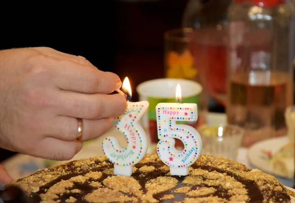 我们在蛋糕上点上数字形式的蜡烛 庆祝35岁 蛋糕上点着蜡烛 免版税图库照片