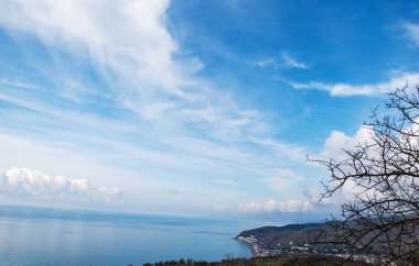 Güzel bir körfezin üzerindeki bulutlu mavi gökyüzü, yukarıdan görünüyor..