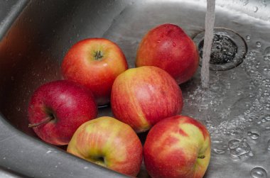 Elmalar kırmızı ve tatlıdır, evde meyve yıkarlar.