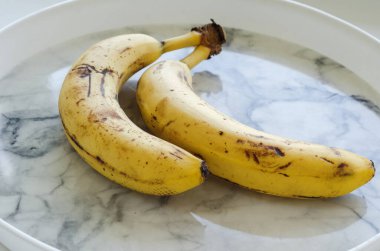 Plastik bir tabakta iki olgun muz