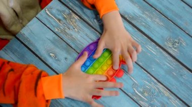 Çocuk popüler stres önleyici oyuncağı basit gamzeyi oynuyor.