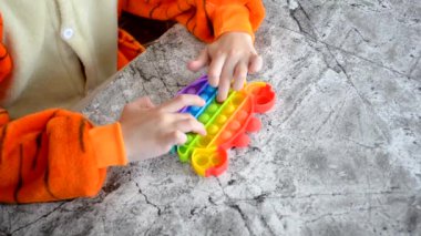 Çocuk popitte elleriyle oynuyor.