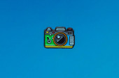 smaltované kovové brož kamera ikona na modrém pozadí