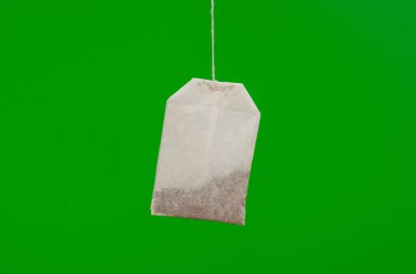 Yeşil arka planda siyah çay poşeti