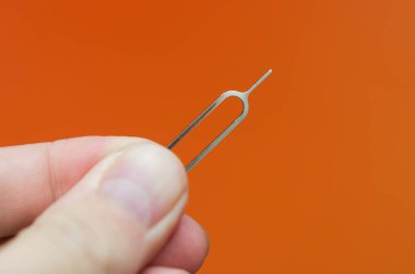 SIM kart fırlatma aracı turuncu arka planda elinde akıllı telefonda