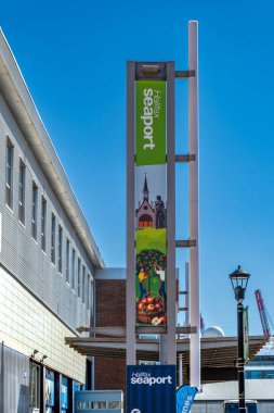 Halifax, NS - Sep 29, 2025 Halifax Limanı 'nda bir kilise, bir heykel ve parlak mavi gökyüzü altında elma toplayan insanların resimleriyle birlikte dikey bir pankart..