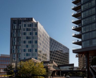 Boston, MA - ABD - 2 Ekim 2025 Modern bir Hyatt Place oteli ve balkonları olan bir apartman Seaport Bölgesi 'nde açık mavi bir gökyüzünün altında duruyor..