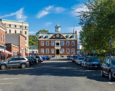Newport, RI - ABD - 3 Ekim 2025 Newport, Rhode Island 'daki tarihi tuğla pazarı ve tarihi koloni evinin görkemli manzarası, park halindeki arabalar ve ağaçlar tarafından çerçevelenmiştir..