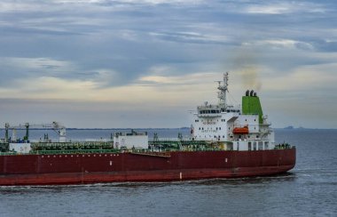 Brooklyn, New York - ABD 27 Şubat 2025 Büyük kırmızı ve beyaz gümüş rengi Valerie, bir kimyasal ve petrol ürünü tankeri bulutlu bir gökyüzünün altında sakin sularda yüzüyor.