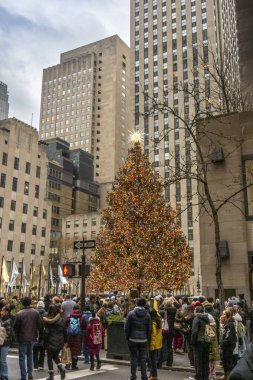 New York, New York - ABD - 13 Aralık 2025 Manhattan şehir merkezi sokak sahnesi SoconyMobil Binası, Uluslararası Style Moderne ofis kulesi ve New York City hareketini yakalayan bulanık sarı bir taksi