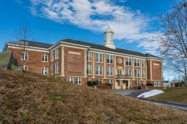 Greenwich, CT - ABD - 11 Ocak 2026 Koloni tarzı kırmızı tuğlalı Cos Cob Okulu 'nun dörtte üçü, bir kış günü açık mavi gökyüzüne karşı beyaz bir kubbenin yer aldığı bir devlet okulu..