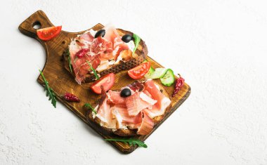 Prosciutto, salatalık, siyah zeytin, roka ve peynirli sandviç..