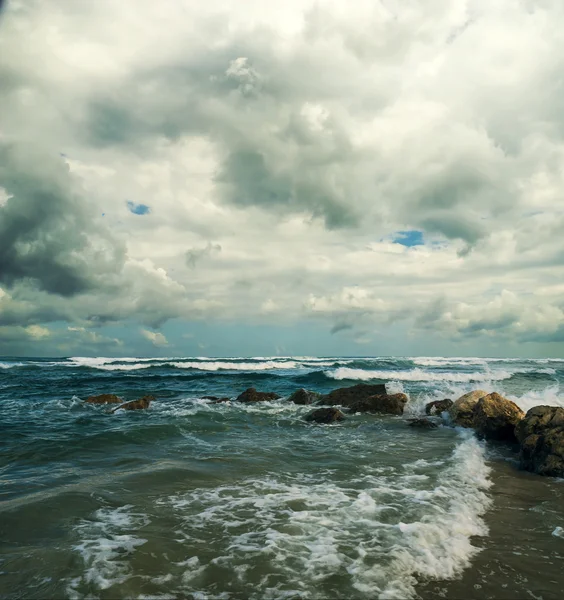 Moře s kameny a zamračená obloha — Stock fotografie