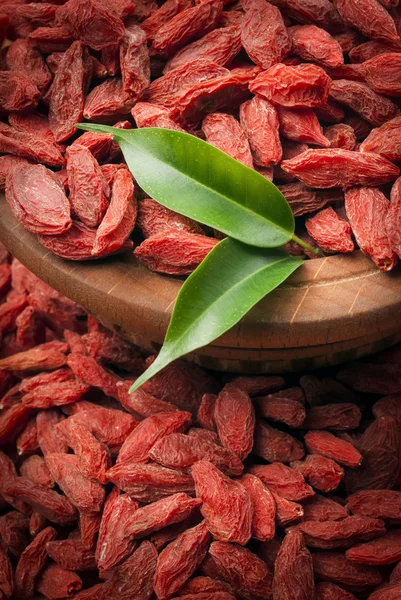 Dried goji berries with green leaves — Stock Photo, Image