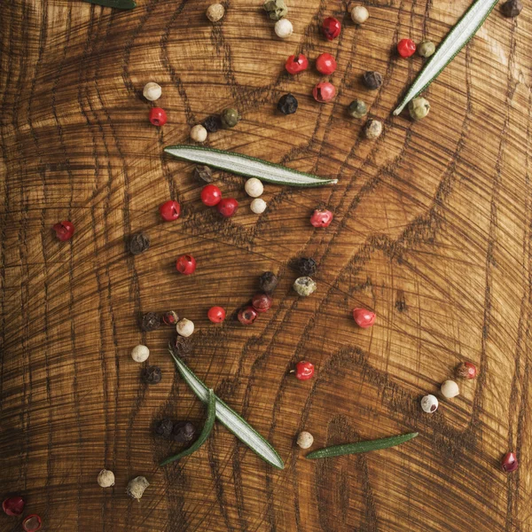 Pepper and  rosemary  on cutting board — Stock Photo, Image