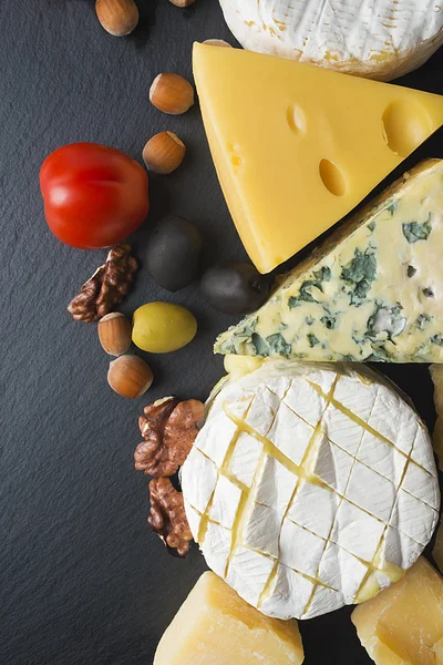 Diferentes variedades de queijo, tomate e nozes — Fotografia de Stock