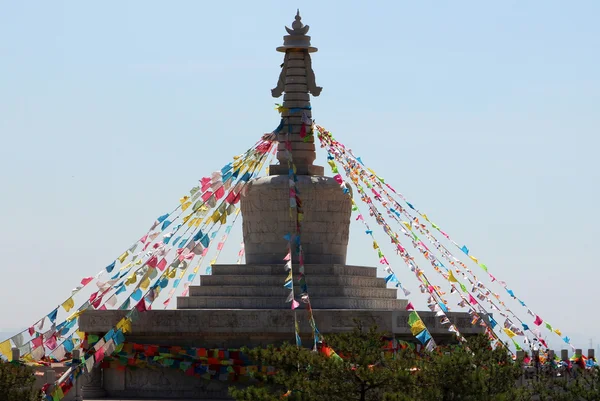 Buddhistická stúpa s modlitbami vlajky na vrcholu kopce, Daqing horsk — Stock fotografie