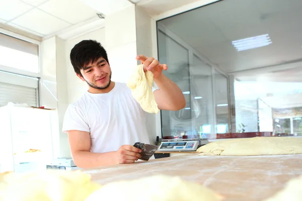 Joven Panadero Tiene Una Porción Pasta Sus Manos Proceso Elaboración — Foto de Stock