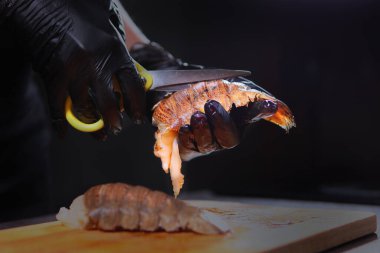 Aşçı ıstakoz kabuğunu makasla keser. Deniz mahsulleri pişiriyorum. Sağlıklı protein yiyeceği. Tanımlanamayan kişi. Ellerinizi koruyucu eldivenlere koyun. Boşluğu kopyala.