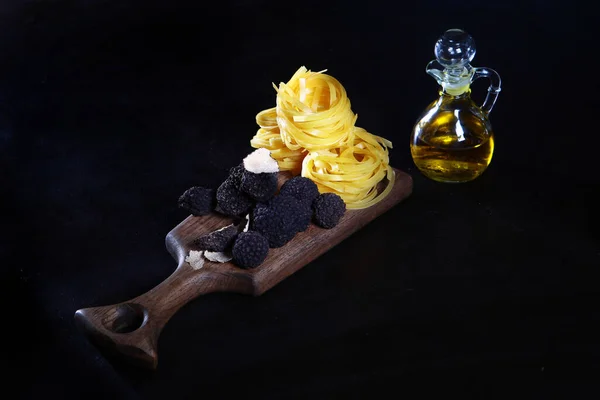 Black truffle on a wooden Board with nest paste and olive oil. The season of truffles. Natural antioxidant and protein. The most expensive mushroom. — Stock Photo, Image